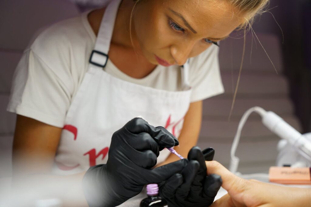 nail technician doing nails; how to become a nail tech